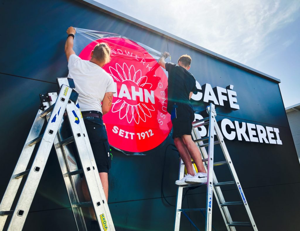 Montage der Beschilderung für eine neue Bäckerei